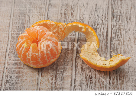 tangerine with peeled peel on a wooden background tangerine with peeled peel on a wooden background 87227816