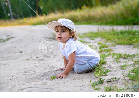 little girl sit in sand in counrtyside little girl sit in sand in counrtyside 87228087