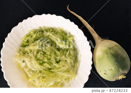 green radish salad in a white plate - top view 87228233