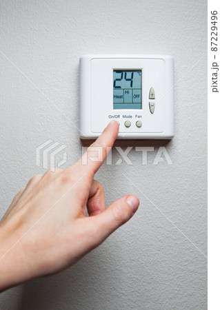 hand turning on digital climate control 87229496