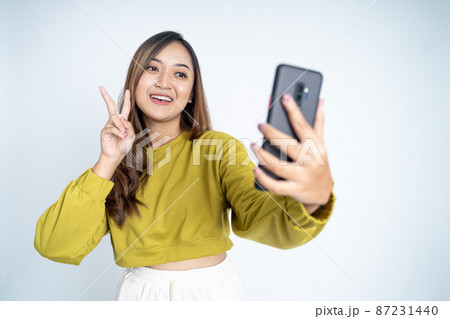 young woman take a selfie with peace hands gesture young woman take a selfie with peace hands gesture 87231440