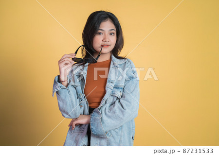 attractive asian girl looking at camera while taking off sunglasses 87231533