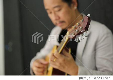 Portrait of men musician playing guitar in studio. 87231787