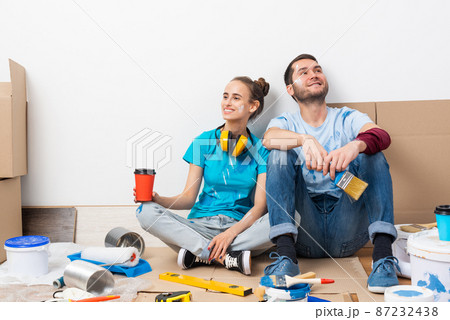 Happy boy and girl drinking coffee on floor. Happy boy and girl drinking coffee on floor. 87232438