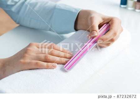 Woman using nail file and create nails shape 87232672