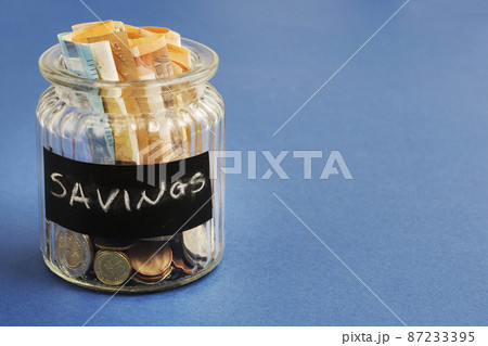 saving bottle with euro notes coins blue background saving bottle with euro notes coins blue background 87233395