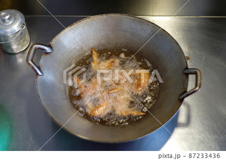 Top view many piece of chicken wings deep fried in the boiled vegetable oil. Top view many piece of chicken wings deep fried in the boiled vegetable oil. 87233436