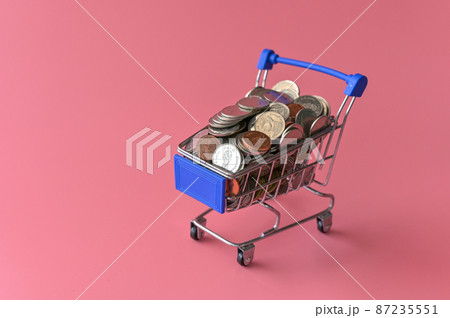 Many coins in the blue shopping cart Isolated on pink background and copy space, saving and investment concept Many coins in the blue shopping cart Isolated on pink background and copy space, saving and investment concept 87235551