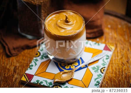 Dalgona coffee drink background. Korean coffee drink made with whipped instant coffee, sugar and milk. Dalgona coffee drink background. Korean coffee drink made with whipped instant coffee, sugar and milk. 87236035