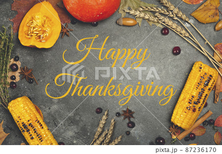 Happy Thanksgiving lettering on a festive dinner background. Food table background with autumn seasonal specialties for Thanksgiving Day. Fried chicken with pumpkin, vegetables and autumn decor 87236170