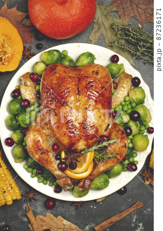 Thanksgiving turkey or chicken for a festive dinner. Food table background with autumn seasonal specialties for Thanksgiving Day. Fried chicken with pumpkin, vegetables and autumn decor on a wooden 87236171