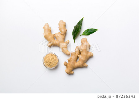 Finely dry Ginger powder in bowl with green leaves isolated on colored background. top view flat lay 87236343