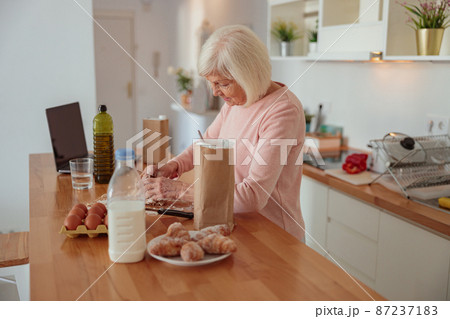 Elderly female molding homemade baking in kitchen 87237183