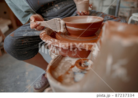 Female potter master working on craft in clay studio Female potter master working on craft in clay studio 87237334