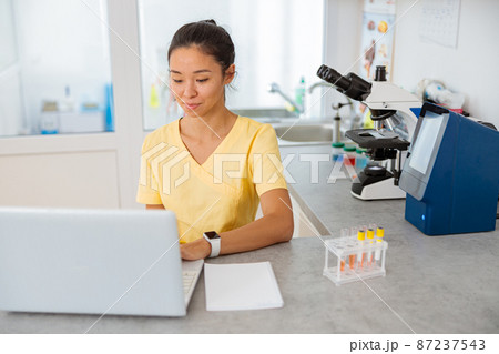 Female vet assistant using laptop in lab Female vet assistant using laptop in lab 87237543