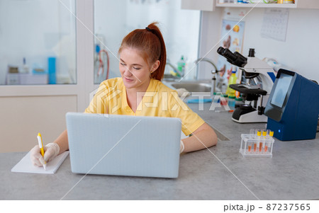 Woman vet works with laptop at medical office Woman vet works with laptop at medical office 87237565