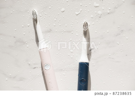 New modern ultrasonic toothbrush with splashes and drops of water on marble background. Oral hygiene, dental and gum health, healthy teeth. Dental products Ultrasonic vibration toothbrush. 87238635