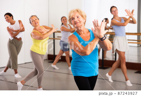 Group of active women practicing energetic dance in a studio 87243927