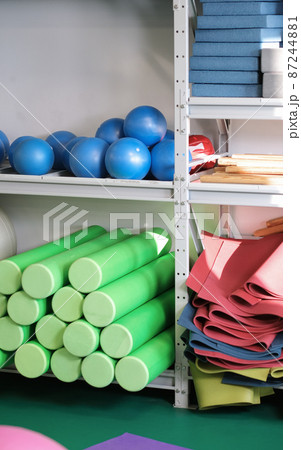 pilates and yoga equipment in a fitness gym. balls, mats and foam rollers on shelfs. stretching and relaxation pilates and yoga equipment in a fitness gym. balls, mats and foam rollers on shelfs. stretching and relaxation 87244881