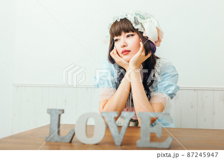LOVEの文字の前でうつむく女性　Cosplay 87245947