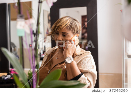 Small business Latin entrepreneur using smartphone technology for her professional beauty salon Small business Latin entrepreneur using smartphone technology for her professional beauty salon 87246290