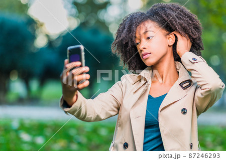 young afro hair Latin woman selfie in winter clothes with smartphone Dominican Republic lifestyle young afro hair Latin woman selfie in winter clothes with smartphone Dominican Republic lifestyle 87246293