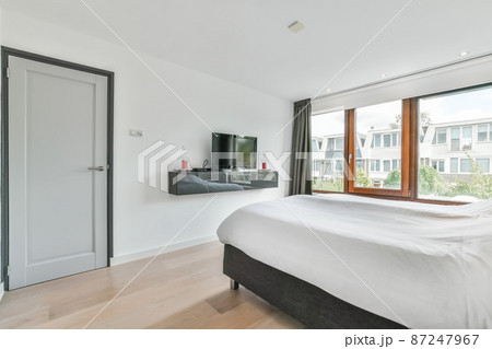 Large double bed with wooden windows and TV opposite 87247967