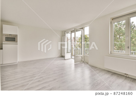 an empty hall with opened glass doors entering to the balcony 87248160