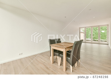 a set of wooden table and black chairs in an empty room a set of wooden table and black chairs in an empty room 87248198