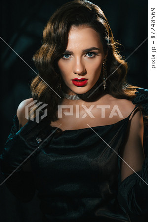 Portrait of a woman in the style of a classic retro Hollywood movie of the 1950s. Elegant young girl with a stylish hairstyle and makeup Portrait of a woman in the style of a classic retro Hollywood movie of the 1950s. Elegant young girl with a stylish hairstyle and makeup 87248569