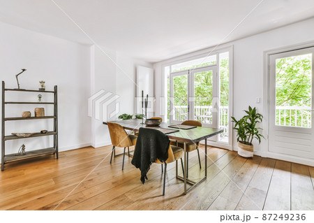 A stylish room with a dining area with a wooden table in daylight 87249236