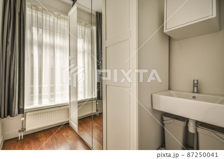 Small narrow storage room with large mirror 87250041