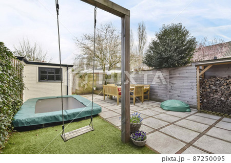 Compact backyard with dining area and play area for kids 87250095