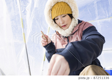 ワカサギ釣りをする若い女性 87251336