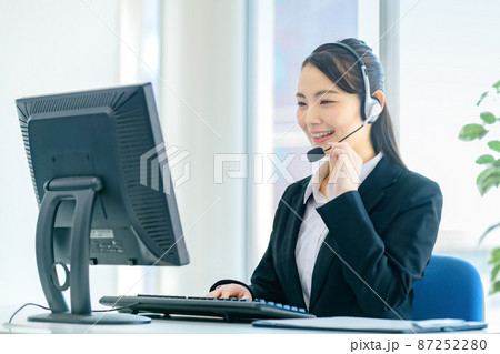 オフィスでヘッドセットを付けてチャットする若い女性オペレーター オフィスでヘッドセットを付けてチャットする若い女性オペレーター 87252280