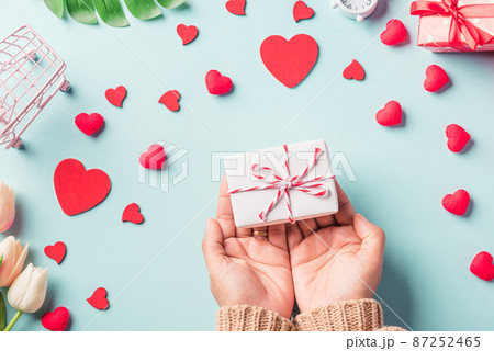 Woman hands holding gift or present box decorated and red heart surprise Woman hands holding gift or present box decorated and red heart surprise 87252465