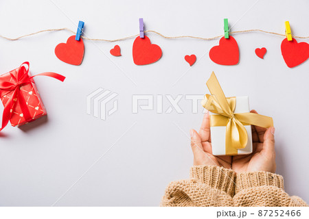 Woman hands holding gift or present box decorated and red heart surprise Woman hands holding gift or present box decorated and red heart surprise 87252466