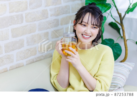 リビングでお茶を飲む若い女性 87253788