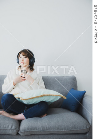 女性 ヘッドフォン スマホ リビング 女性 ヘッドフォン スマホ リビング 87254920