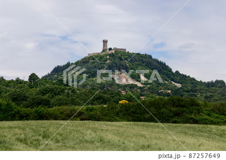 Rocca of Radicofani fortress on the top of a green Tuscan hill from. Italy 87257649