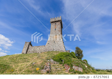 Brick tower Rocca of Radocofani on top the basalt hill with sky background on a summer day, Tuscany 87257661