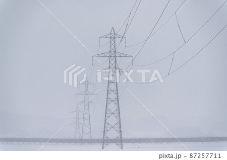 雪の中の鉄塔と送電線 87257711