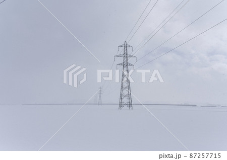 雪の中の鉄塔と送電線 87257715