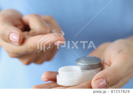 Contact lenses for vision and a container in female hands, blurry 87257829
