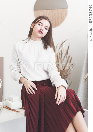 Portrait of fashionable women in red skirt and white blouse posing in a bath 87258749