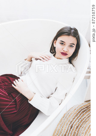 Portrait of fashionable women in red skirt and white blouse posing in a bath Portrait of fashionable women in red skirt and white blouse posing in a bath 87258759
