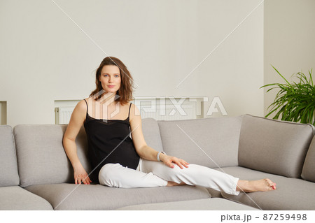 Pregnant woman on sofa at home 87259498