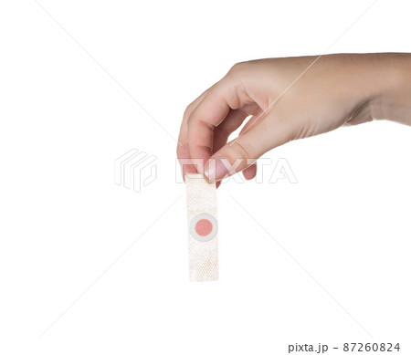 The girl holds in her hand a medical plaster against core calluses on the soles of the feet. White background, isolate The girl holds in her hand a medical plaster against core calluses on the soles of the feet. White background, isolate 87260824