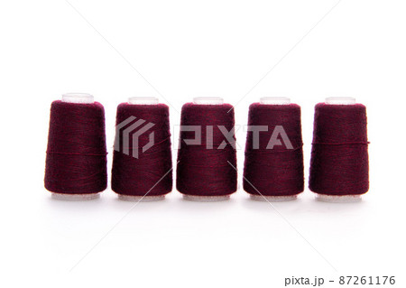 Red spool of thread isolated on white background. Skein of woolen threads. Yarn for knitting. Materials for sewing machine. Coil. Red spool of thread isolated on white background. Skein of woolen threads. Yarn for knitting. Materials for sewing machine. Coil. 87261176