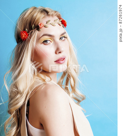 young blond woman dressed like ancient greek godess, beautiful girl hands manicured red nails on blue background copyspace 87261974